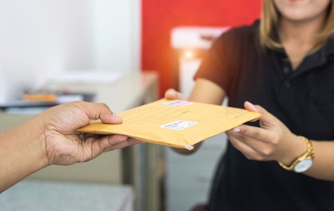 Sample mailer being handed over at the post office